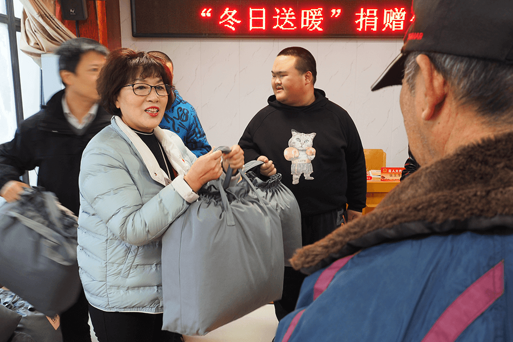 区人大代表刘潭服装董事长钱玉萍接待选民并捐赠暖被